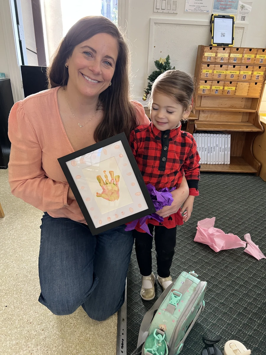 A parent and child bonding over the child's artwork, sharing a moment of pride and creativity together.