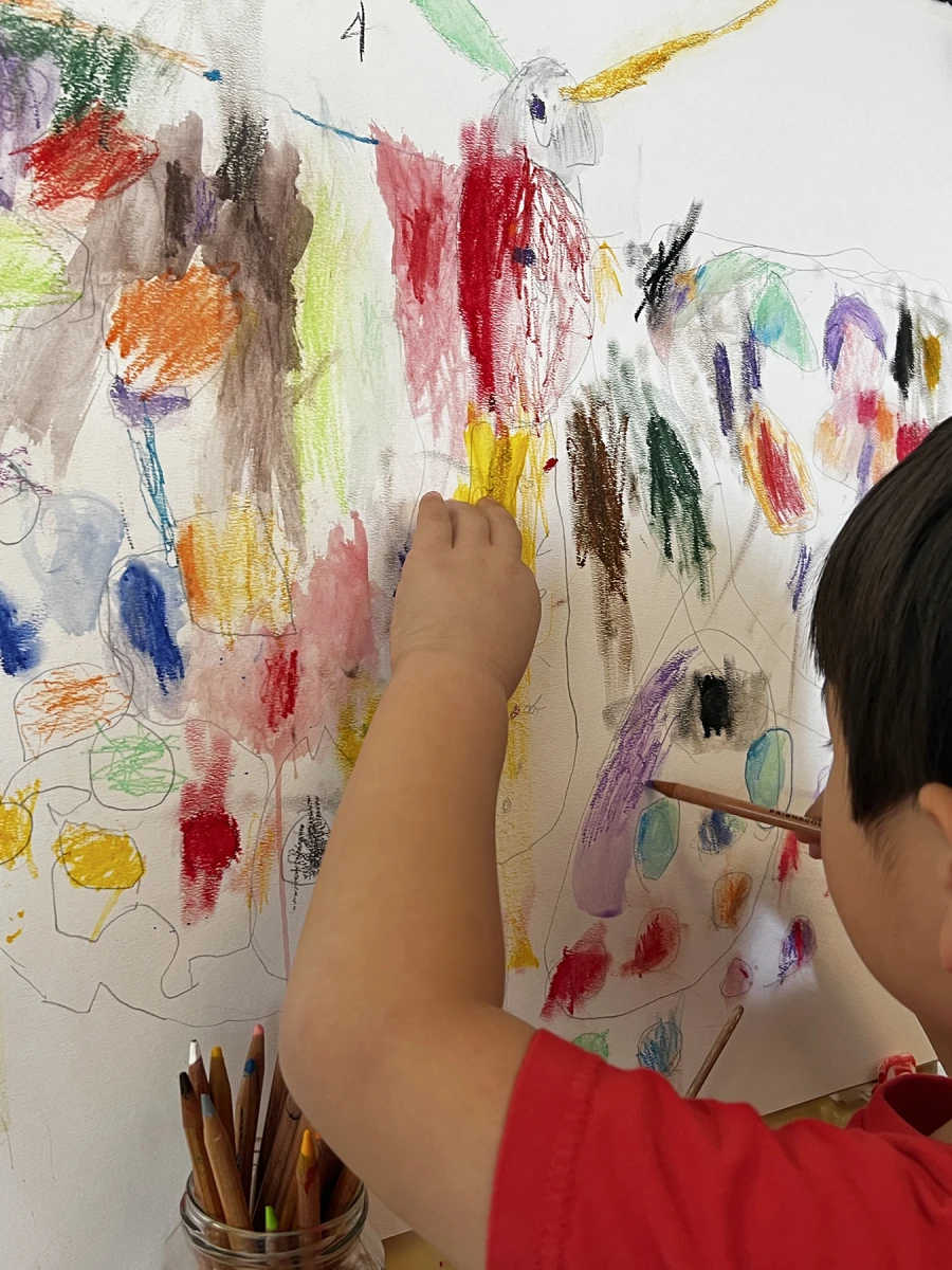A child working on a large-scale collaborative butterfly artwork, contributing their creativity to a shared masterpiece.